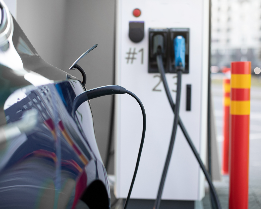 An electric vehicle NACS charger plugged into a public charging station, links to charger lock page