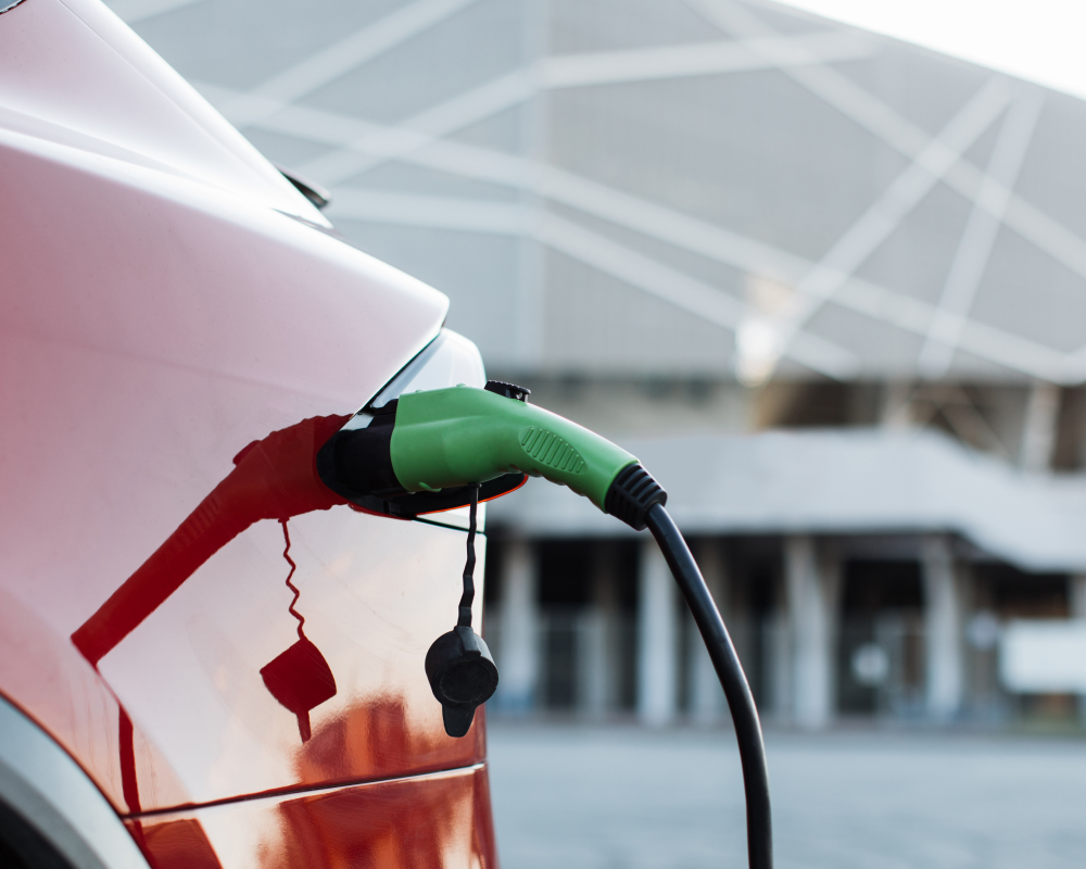 A J1772 charging plug connected to electric vehicle being charged, links to LENZ adapters page